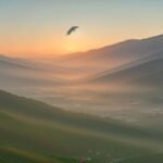 A paraglider drifting over misty mountains and a quiet village at golden hour, evoking a romantic K-drama
